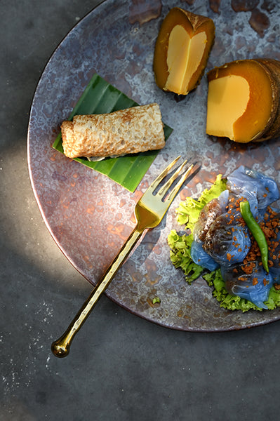 Polished stainless steel dessert fork with twisted hammered handle, top view