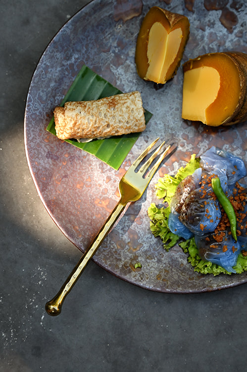 Polished stainless steel dessert fork with twisted hammered handle, top view