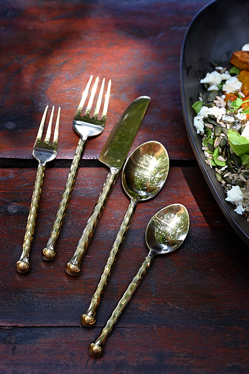 Hand-forged Ayutthaya cutlery set styled with food for a Singapore home dinner
