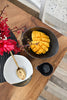 The Intimate Table in use — Charcoal Grill Shell Dish holding cubed mango, with Gold Leaf Bowl and Bamboo gold serving spoon