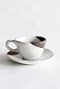 Gold leaf espresso cup resting on a matching ceramic saucer