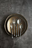 Set of silverware on a dark plate against a gray background