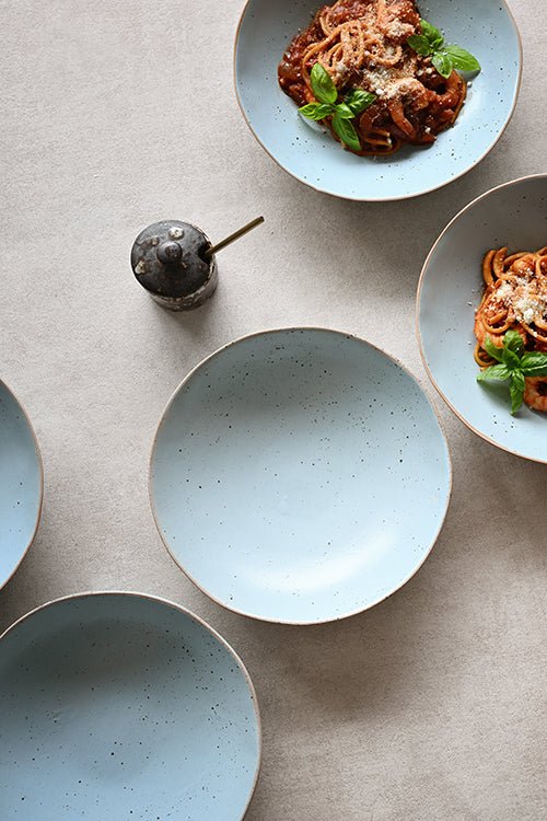 light blue speckled ceramic plate bowls on a neutral beige surface, handmade durable stoneware ships in Singapore