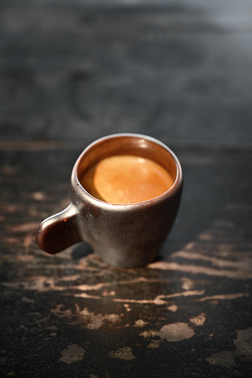 Wok Hei flat-handle ceramic espresso cup in charcoal with swirling brushstroke, three-quarter view